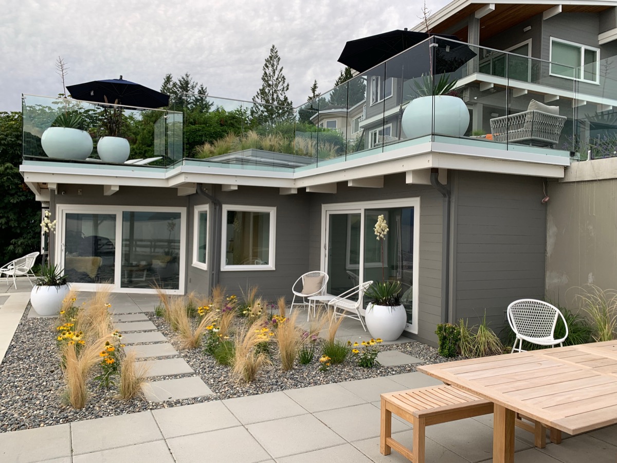 Residential project with white planters on a rooftop patio and front garden