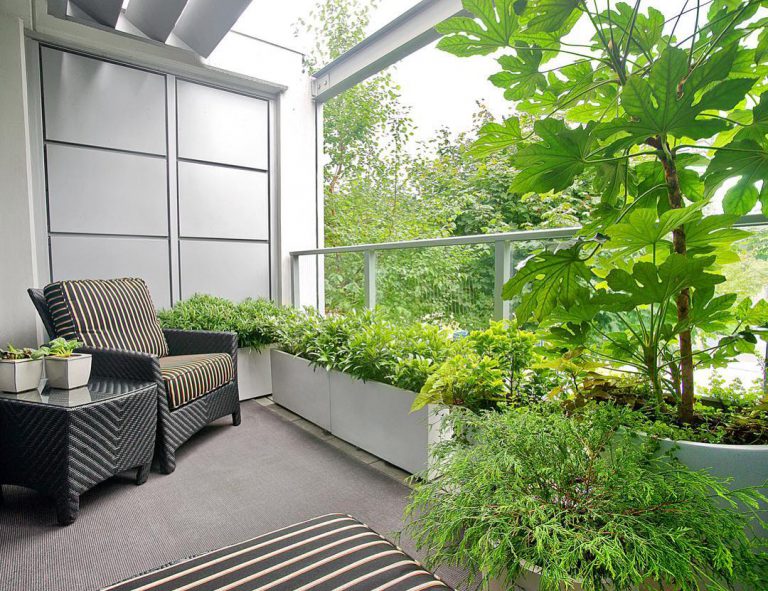 A collection of large white fiberglass outdoor planters for a modern balcony garden.