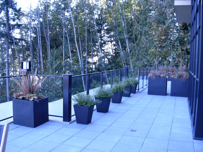 An array of black fiberglass outdoor planters installed at a Whistler residence, combining durability and visual balance.