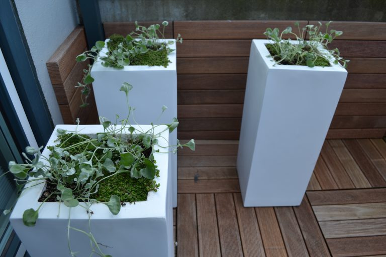 The fiberglass Ruben Tall Square planters offering architectural impact on a deck.