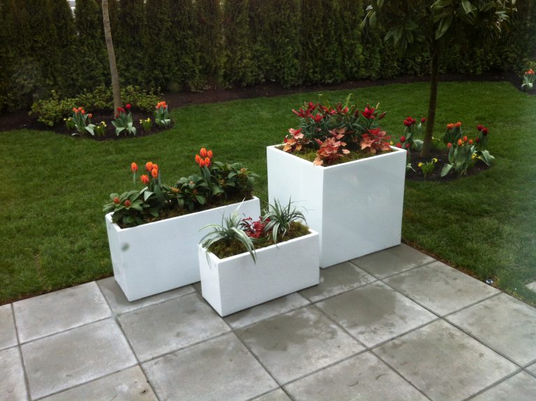 Coordinated set of large fiberglass outdoor planters for a contemporary landscape design.